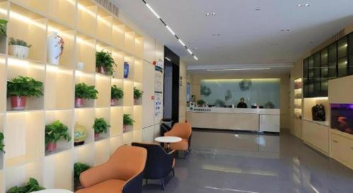 a lobby with chairs and plants on the wall at GreenTree Inn Express Fuyang University Town West High-Speed Railway Station in Fuyang