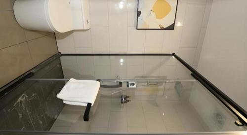 a glass room with a white chair in a bathroom at GreenTree Inn Express Fuyang University Town West High-Speed Railway Station in Fuyang