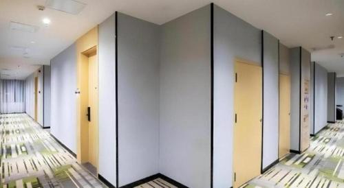 a row of doors in a hallway with mirrors at GreenTree Inn Express Fuyang University Town West High-Speed Railway Station in Fuyang
