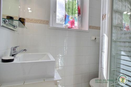 a white bathroom with a sink and a window at Villa la lieue de greves in Plestin-les-Grèves