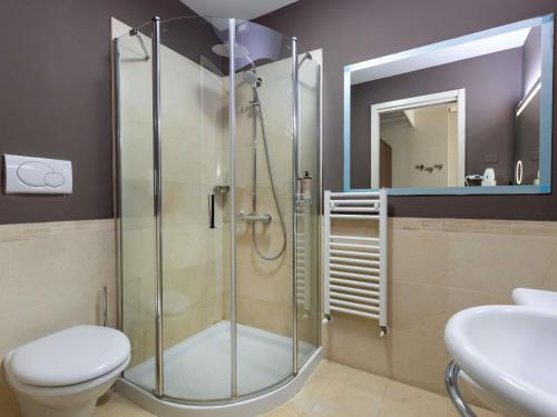 a bathroom with a shower and a toilet and a sink at Mercure Rimini Lungomare in Rimini