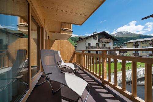a balcony with chairs and a view of a mountain at Bivio Hotel Plaza in Livigno