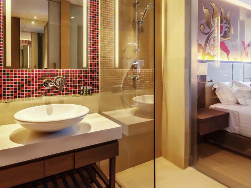 a bathroom with a sink and a shower at Grand Mercure Phuket Patong in Patong Beach