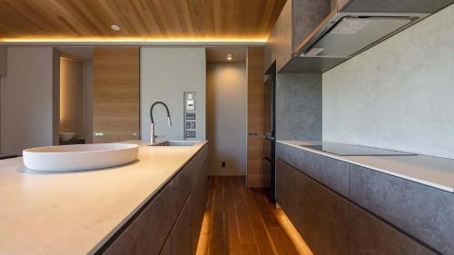 a bathroom with a sink and a large mirror at Rinzan Chalet by Elite Havens in Niseko