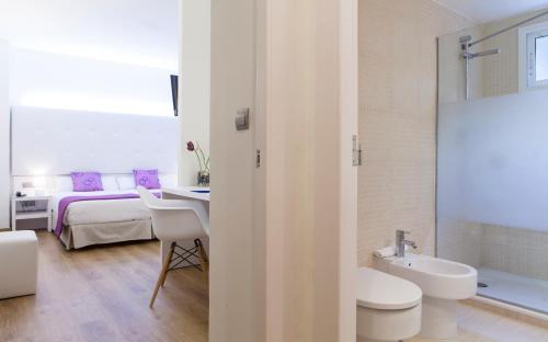 1 cama y baño con lavabo y aseo. en Hotel Albahia Alicante, en Alicante