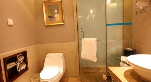 a bathroom with a toilet and a sink and a shower at Zhangjiagang Guomao Hotel in Zhangjiagang
