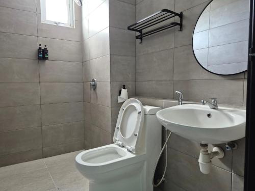 a bathroom with a sink and a toilet and a mirror at Metropol by BRB in Bukit Mertajam
