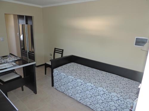 a bedroom with a bed and a desk and a mirror at Apart Belgrano in Posadas