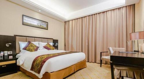 a hotel room with a large bed and a desk at Nanning Yongjiang Hotel in Nanning