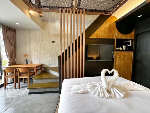 a bedroom with a bed with two white swans on it at Lalalune Khao Sok Resort & Lifestyle in Khao Sok