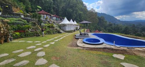 a resort with a blue pool in the grass at Adelisca Glamping, Villa & Cafe in Kubupenlokan
