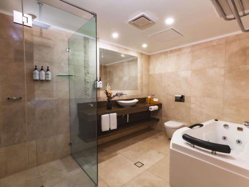 a bathroom with a shower and a toilet and a sink at Fairmont Resort Blue Mountains MGallery Collection in Leura