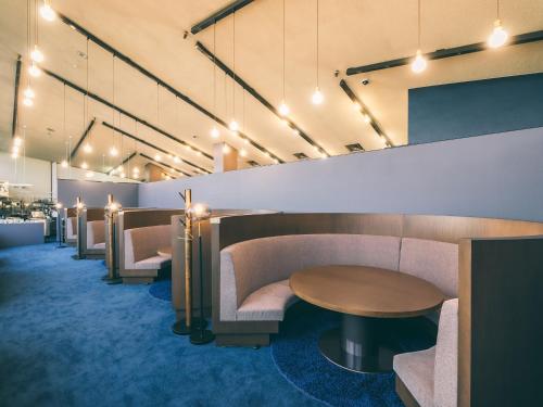 a waiting room with couches and tables and lights at Hotel Alpen Blick in Myoko