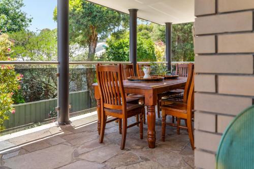 a porch with a wooden table and chairs on a balcony at Hunter House - Castlemaine in Castlemaine