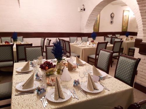 a dining room with tables with white tablecloths and chairs at Hotel Royal Craiova in Craiova
