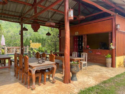 un patio con tavolo, sedie e TV di Nai Khun Khao Resort a Chiang Mai