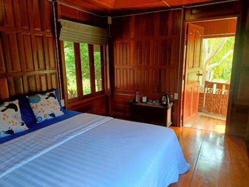una camera da letto con un letto in una stanza con pareti in legno di Nai Khun Khao Resort a Chiang Mai
