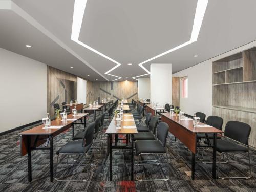 a row of tables and chairs in a restaurant at Ibis Jakarta Senen in Jakarta