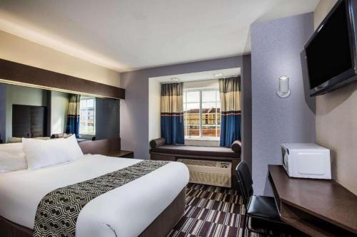 チャタヌーガにあるMicrotel Inn & Suites by Wyndham Chattanooga/Near Hamilton Pのベッドとテレビがあるホテルの部屋