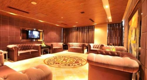 a large room with leather furniture and a flat screen tv at Excemon Yuyao Hemudu Hotel in Ningbo