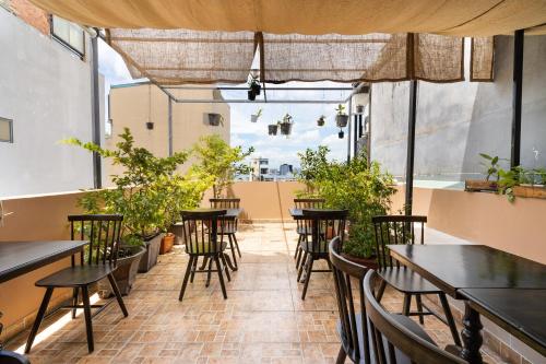 una fila de mesas y sillas en un patio con plantas en HemTouch House - Nguyễn Văn Mai, en Ho Chi Minh