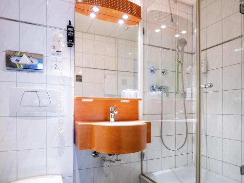 a bathroom with a sink and a shower at ibis Styles Luzern in Luzern