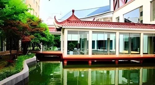 a building next to a body of water at Huangshan Shuguang Yusong Hotel in Huangshan