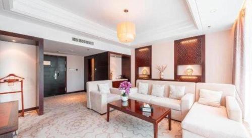 a living room with a white couch and a table at Huangshan Shuguang Yusong Hotel in Huangshan