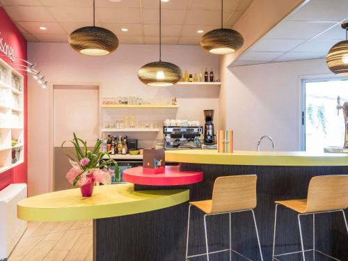 a restaurant with yellow and red tables and chairs at ibis styles Dax Centre in Dax