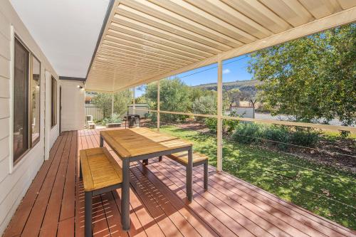 a wooden deck with a wooden table and benches at Alice Village in Alice Springs