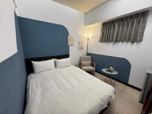 a bedroom with a white bed and a chair at 檸檬樹 in Taichung