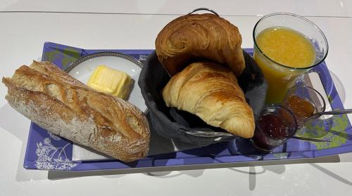 a tray of bread and croissants and a glass of orange juice at Chez Annick, studio proche tram, Groupama Stadium, LDLC Arena in Décines-Charpieu