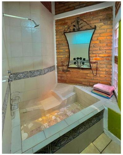a bathroom with a shower with a sink and a tub at Casa CABAÑA CHULA VISTA a 5 minutos del centro in Tequila