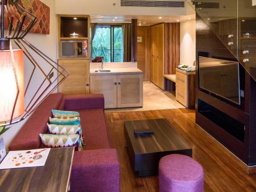 un soggiorno con un divano e un tavolo di Novotel Goa Resort & Spa Candolim a Candolim