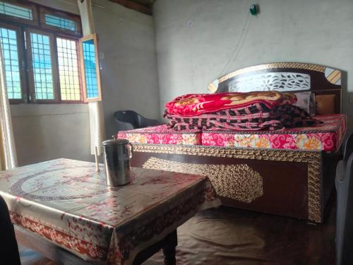 a room with a bed and a table with a table sidx sidx at Top hill home stay in Sāma