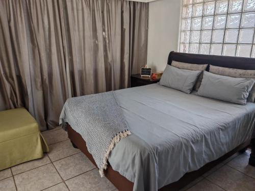 una camera da letto con un letto grande e una finestra di Yakhe self-catering Cozy styled 1 bedroomed a Edenvale