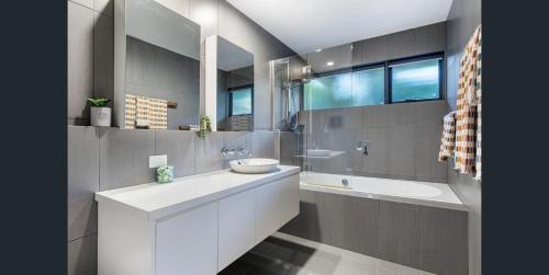 a bathroom with a white sink and a tub and a sink at Bush & Beach Retreat,Near Golf Course Yaroomba in Yaroomba