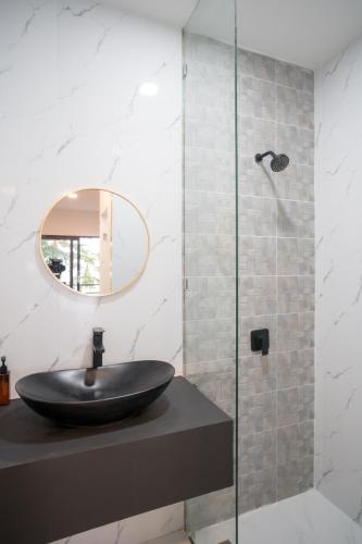 a bathroom with a black sink and a mirror at Pine Bungalow Krabi in Klong Muang Beach