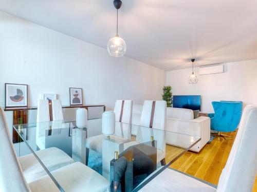 a living room with a glass table and white chairs at Vita Portucale ! Benfica Lux Garden in Lisbon
