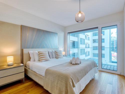a bedroom with a large bed and a large window at Vita Portucale ! Benfica Lux Garden in Lisbon