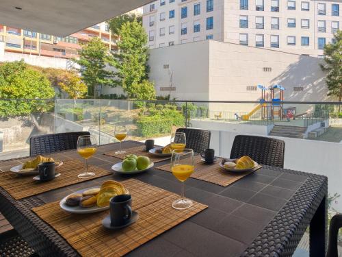 a table with food and wine glasses on a balcony at Vita Portucale ! Benfica Lux Garden in Lisbon