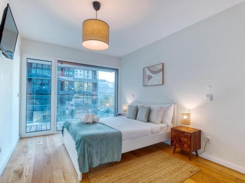 a bedroom with a bed and a large window at Vita Portucale ! Benfica Lux Garden in Lisbon