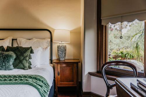 a bedroom with a bed and a window and a lamp at Green Gables King Suite in Castlemaine