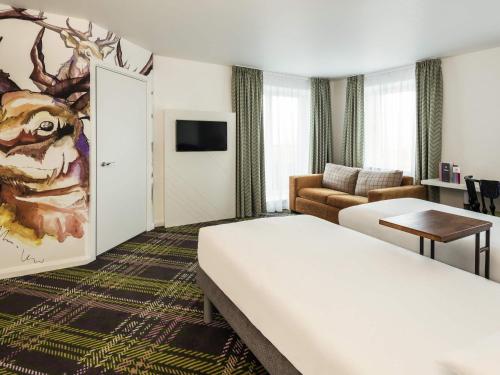 a hotel room with a bed and a living room at ibis Styles Edinburgh St Andrew Square in Edinburgh