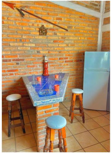 a kitchen with a counter with a sink and stools at Casa CABAÑA CHULA VISTA a 5 minutos del centro in Tequila