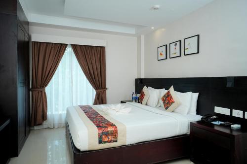 Кровать или кровати в номере D Fort Hotel Kollam