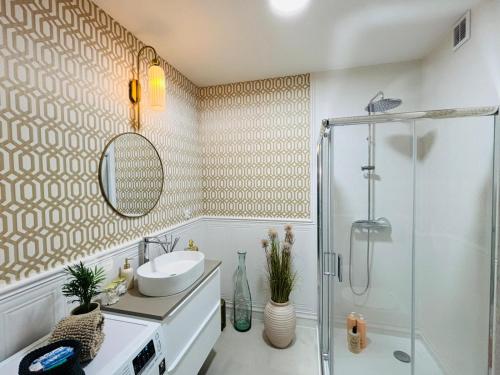 a bathroom with a sink and a shower at Apartament Kaszmirowy in Grudziądz