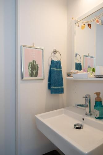 a bathroom with a white sink and a mirror at KIYAZA RESORT Kamakura in Kamakura