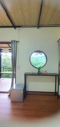 una stanza con tavolo e finestra rotonda di วาคุมิคาเฟ่&โฮมสเตย์ WakumiCafe&Homestay a Ban Pong