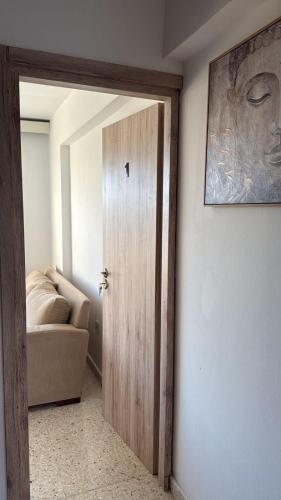 una puerta en una habitación con sofá y una foto en Larnaca Ancient View Rooms, en Lárnaca